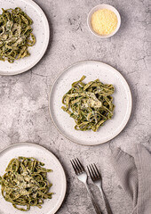 Wall Mural - Food photography of pasta; tagliatelle, fettuccine; trenette; spinach; oregano; parmesan; cheese; sauce, olive; oil; durum; wheat; semolina; fork; background; italian