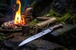 knife and whetstone near a campfire outdoor