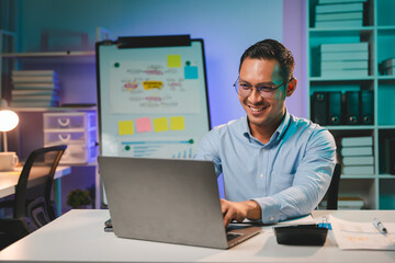 business man working late at night use laptop at desk Happy male portrait working IT, face and male coder or person programming Coding and Writing for Software or Information Technology Development