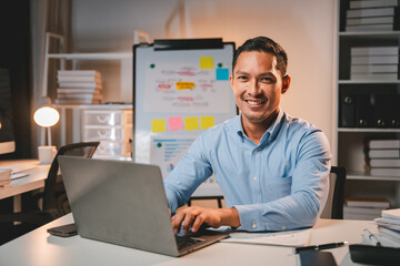business man working late at night use laptop at desk happy male portrait working it, face and male 
