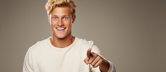 Poster - Cheerful young man pointing happily to object in copy space