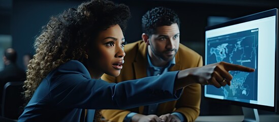 African American woman directing trainee in office with computer copy space