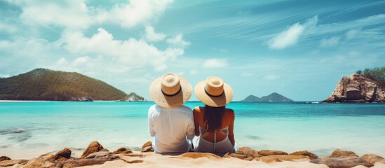 Sticker - A couple in hats admires the turquoise ocean from a tropical beach on their summer vacation