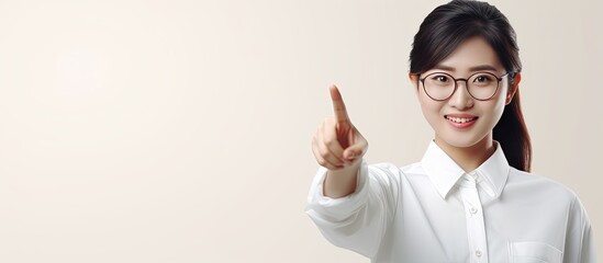 Poster - Smiling Asian woman in white shirt pointing to empty space