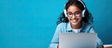 Smiling Indian Teen Girl Using Laptop For Online Study On Blue Background Happy Student In Educational Webinar
