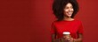 © HN Works - Smiling young African American woman holding a coffee to go isolated on a red background