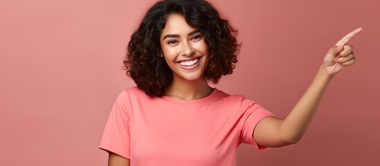 Poster - Smiling cheerful Hispanic woman happily pointing to side and upwards displaying object in empty area