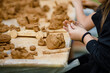 Childrens lesson for modeling from Natural terracotta clay piece held in hands. Wet clay material for sculpture or modeling