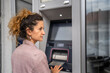 © Miljan Živković - woman using credit card and withdrawing cash at the ATM