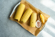 Wooden Chopping Board With Fresh Corn On Table