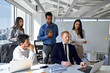 © insta_photos - International business team people working in meeting room with laptop. Busy diverse professional board executives and manager having teamwork discussion managing marketing project at work in office.