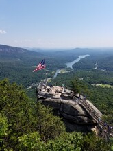 Chimney Rock North Carolina With American Flag And Lake Lure In The Background