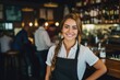 Young female waitress working in a cafe bar smiling