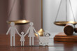 © New Africa - Family law. Figure of parents with children, scales and gavel on wooden table, space for text