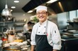 © Baba Images - Middle aged korean chef working in a restaurant kitchen smiling portrait