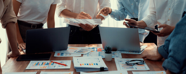 Leinwandbilder - Analyst team utilizing BI Fintech to analyze and pointing at financial dashboard paper office. Businesspeople examining report paper on table for business insight. Panorama shot. Scrutinize