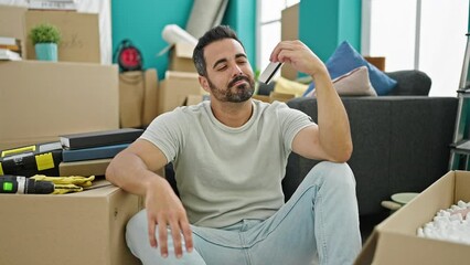 Sticker - Young hispanic man holding credit card thinking at new home