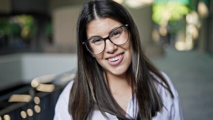 Poster - Young beautiful hispanic woman talking to the camera at the office