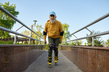 Wall Mural - Brave senior man moving fast on roller skates outdoors