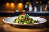 Spaghetti pasta with spinach and green pesto, in a white plate