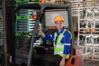 © Hip.hub - Industrial worker driving a forklift in the factory. Engineer is working and maintaining in the warehouse.