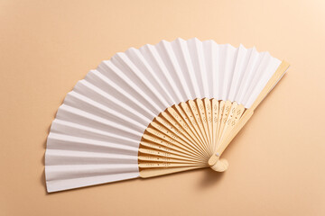 Wall Mural - Folding traditional white hand fan for summer mock-up. Beige background