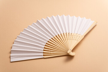 Wall Mural - Folding traditional white hand fan for summer mock-up. Beige background