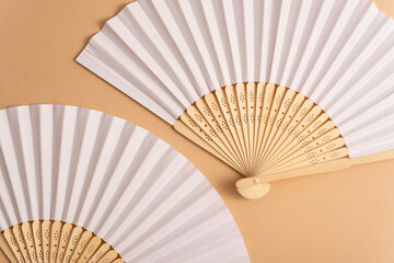 Wall Mural - Folding traditional white hand fan for summer mock-up. Beige background