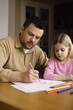 © OMD - a young father studying with his daughter at the dining table