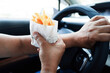 Asian woman driver hold and eat french fries in car, dangerous and risk an accident.