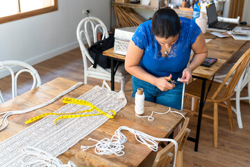 Wall Mural - Head of textile workshop cuts the rope with scissors to make macrame