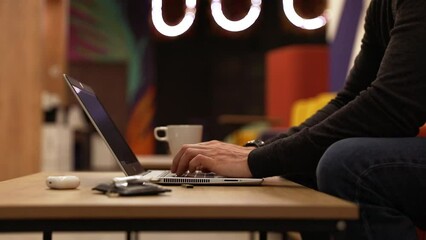 A programmer coding at lap top at coworking space
