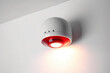 Macro shot of a modern fire alarm mounted on a white wall, emitting bright flashes of light and piercing sounds to alert people in case of fire