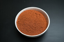 Red Chili Powder On A White Plate On A Black Background