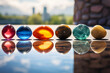 canvas print picture - A set of chakra stones on a reflective surface capturing their colors and shapes.