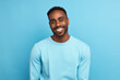 © bomoge.pl - Smiling African American Man with a Playful Expression on Vibrant Blue Studio Background