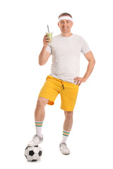 Poster - Sporty mature man with glass of vegetable smoothie and soccer ball on white background