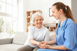 © Pixel-Shot - Senior woman with female caregiver holding hands at home