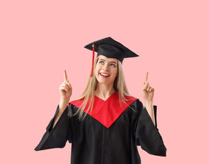 Wall Mural - Female graduate student pointing at something on pink background