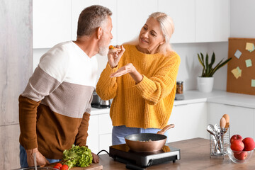 Sticker - Mature couple tasting food in kitchen