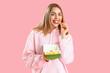 © Pixel-Shot - Beautiful young woman eating french fries on pink background