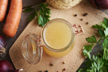 Sticker - Bone broth in a glass jar with carrots, parsley and celeriac, top view