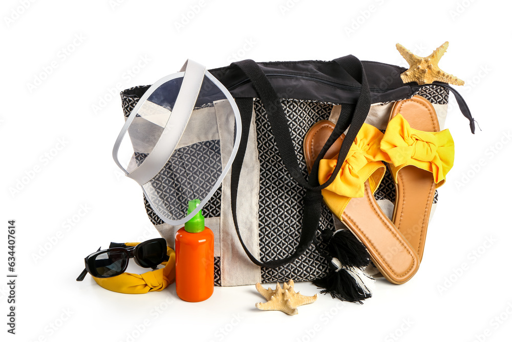 Bottle of sunscreen cream with beach accessories isolated on white background