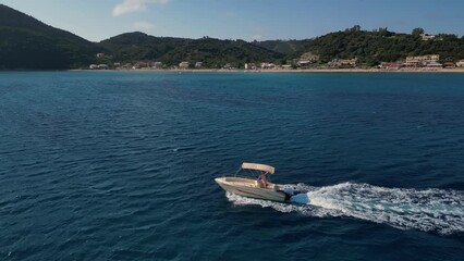 Wall Mural - A small motorboat cruises through the stunning turquoise waters of the Greek islands' serene sea