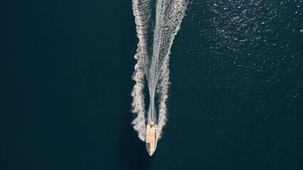 Wall Mural - A small motorboat cruises through the stunning turquoise waters of the Greek islands' serene sea