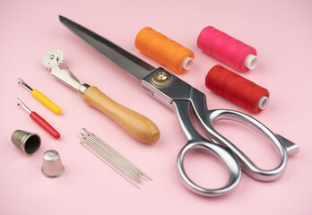 Wall Mural - various tailor accessories and tools for tailoring on a pink background