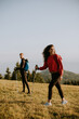 © BGStock72 - Smiling couple walking with backpacks over green hills