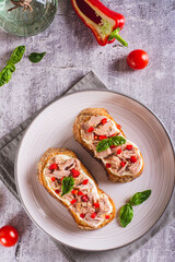 Wall Mural - Toast with canned tuna, cream cheese, peppers and herbs on a plate top and vertical view