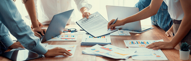 Leinwandbilder - Analyst team utilizing BI Fintech to analyze and pointing at financial dashboard paper office. Businesspeople examining report paper on table for business insight. Panorama shot. Scrutinize