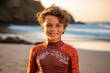 Portrait of smiling little boy in wetsuit on the beach